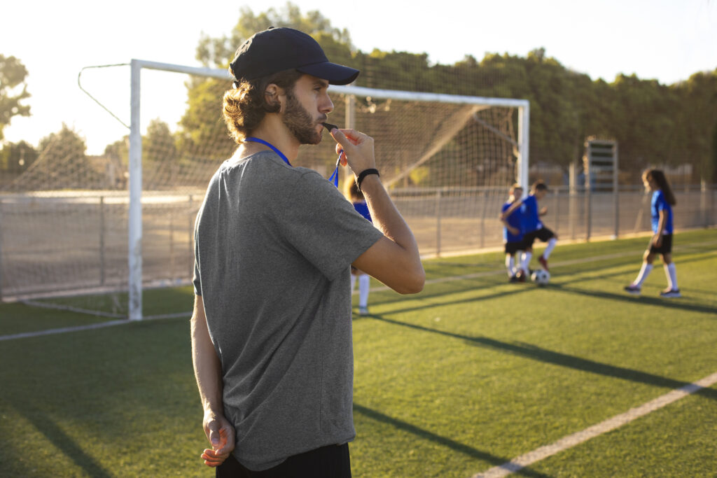 Entrenador corrigiendo la técnica de un futbolista